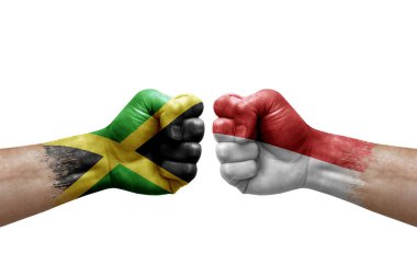 Two hands punch to each others on white background. Country flags painted fists, conflict crisis concept between jamaica and monaco