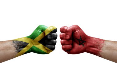 Two hands punch to each others on white background. Country flags painted fists, conflict crisis concept between jamaica and morocco