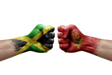 Two hands punch to each others on white background. Country flags painted fists, conflict crisis concept between jamaica and montenegro