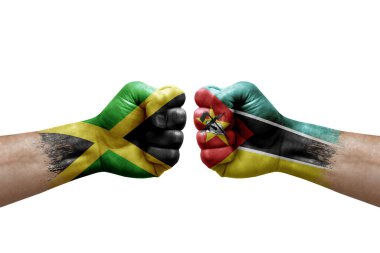 Two hands punch to each others on white background. Country flags painted fists, conflict crisis concept between jamaica and mozambique