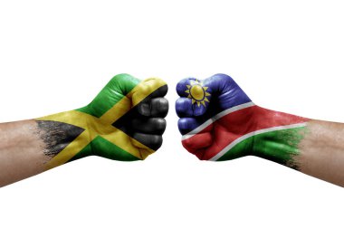 Two hands punch to each others on white background. Country flags painted fists, conflict crisis concept between jamaica and namibia
