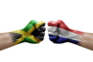 Two hands punch to each others on white background. Country flags painted fists, conflict crisis concept between jamaica and netherlands