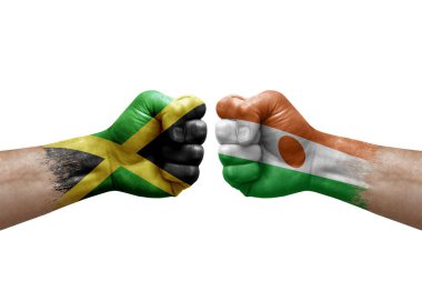 Two hands punch to each others on white background. Country flags painted fists, conflict crisis concept between jamaica and niger