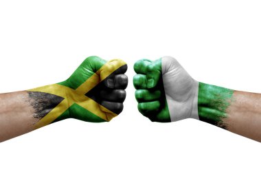 Two hands punch to each others on white background. Country flags painted fists, conflict crisis concept between jamaica and nigeria