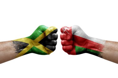 Two hands punch to each others on white background. Country flags painted fists, conflict crisis concept between jamaica and oman