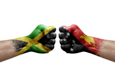 Two hands punch to each others on white background. Country flags painted fists, conflict crisis concept between jamaica and papua new guinea