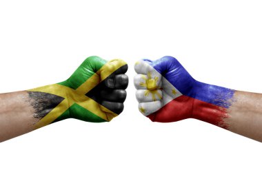 Two hands punch to each others on white background. Country flags painted fists, conflict crisis concept between jamaica and philippines
