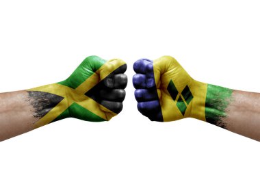 Two hands punch to each others on white background. Country flags painted fists, conflict crisis concept between jamaica and saint vincent and the grenadines