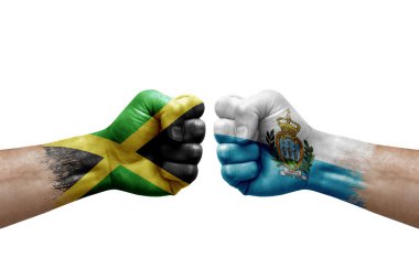 Two hands punch to each others on white background. Country flags painted fists, conflict crisis concept between jamaica and san marino