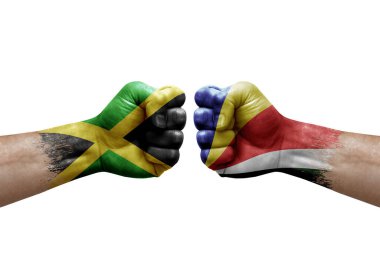 Two hands punch to each others on white background. Country flags painted fists, conflict crisis concept between jamaica and seychelles