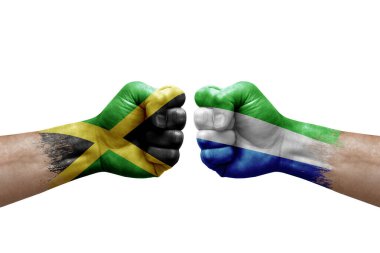 Two hands punch to each others on white background. Country flags painted fists, conflict crisis concept between jamaica and sierra leone