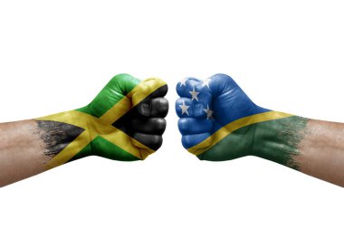 Two hands punch to each others on white background. Country flags painted fists, conflict crisis concept between jamaica and solomon islands