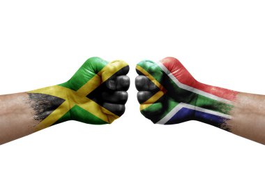 Two hands punch to each others on white background. Country flags painted fists, conflict crisis concept between jamaica and south africa