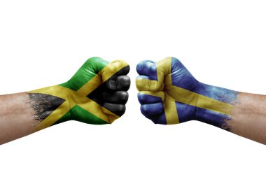 Two hands punch to each others on white background. Country flags painted fists, conflict crisis concept between jamaica and sweden