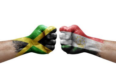 Two hands punch to each others on white background. Country flags painted fists, conflict crisis concept between jamaica and tajikistan