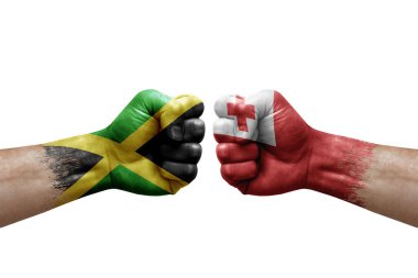 Two hands punch to each others on white background. Country flags painted fists, conflict crisis concept between jamaica and tonga