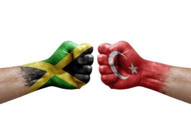 Two hands punch to each others on white background. Country flags painted fists, conflict crisis concept between jamaica and turkey