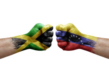 Two hands punch to each others on white background. Country flags painted fists, conflict crisis concept between jamaica and venezuela