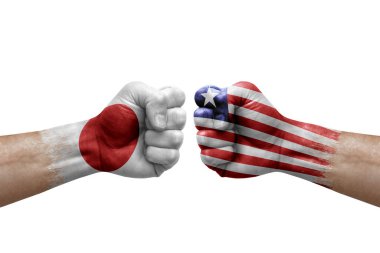 Two hands punch to each others on white background. Country flags painted fists, conflict crisis concept between japan and liberia