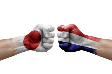 Two hands punch to each others on white background. Country flags painted fists, conflict crisis concept between japan and netherlands