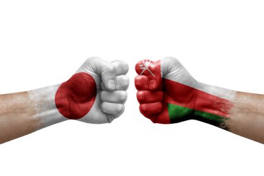 Two hands punch to each others on white background. Country flags painted fists, conflict crisis concept between japan and oman