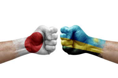 Two hands punch to each others on white background. Country flags painted fists, conflict crisis concept between japan and rwanda