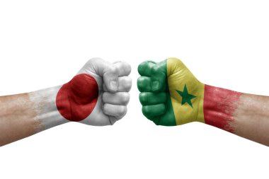 Two hands punch to each others on white background. Country flags painted fists, conflict crisis concept between japan and senegal