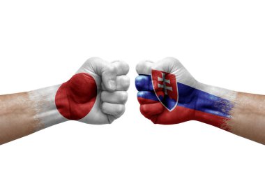 Two hands punch to each others on white background. Country flags painted fists, conflict crisis concept between japan and slovakia