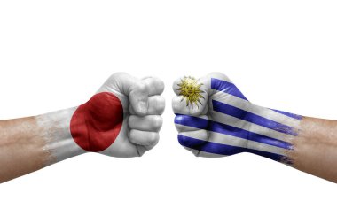 Two hands punch to each others on white background. Country flags painted fists, conflict crisis concept between japan and uruguay