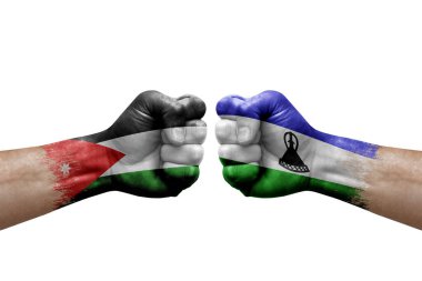 Two hands punch to each others on white background. Country flags painted fists, conflict crisis concept between jordan and lesotho