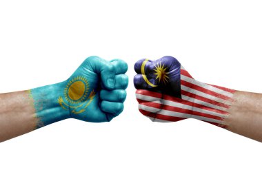Two hands punch to each others on white background. Country flags painted fists, conflict crisis concept between kazakhstan and malaysia