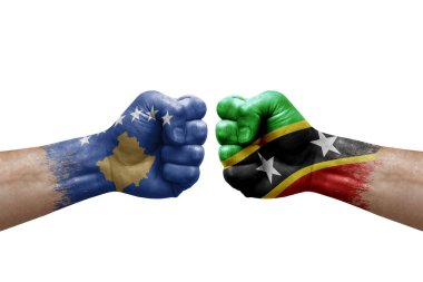 Two hands punch to each others on white background. Country flags painted fists, conflict crisis concept between kosovo and saint kitts and nevis