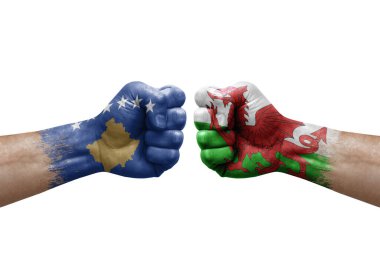 Two hands punch to each others on white background. Country flags painted fists, conflict crisis concept between kosovo and wales