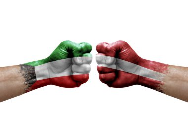 Two hands punch to each others on white background. Country flags painted fists, conflict crisis concept between kuwait and latvia