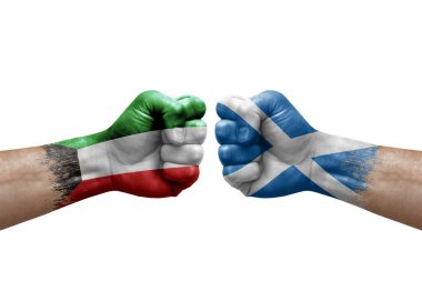 Two hands punch to each others on white background. Country flags painted fists, conflict crisis concept between kuwait and scotland