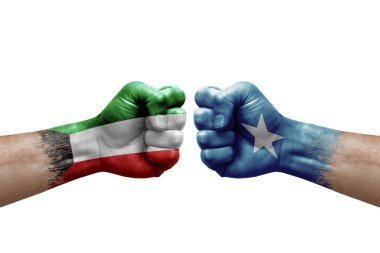 Two hands punch to each others on white background. Country flags painted fists, conflict crisis concept between kuwait and somalia
