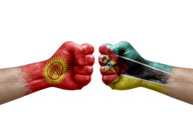 Two hands punch to each others on white background. Country flags painted fists, conflict crisis concept between kyrgyzstan and mozambique