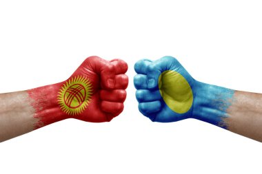 Two hands punch to each others on white background. Country flags painted fists, conflict crisis concept between kyrgyzstan and palau