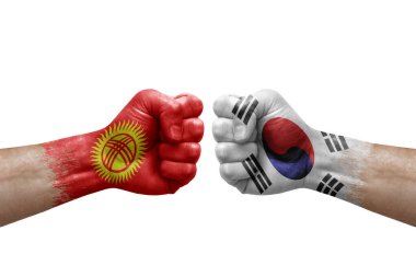 Two hands punch to each others on white background. Country flags painted fists, conflict crisis concept between kyrgyzstan and south korea