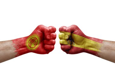 Two hands punch to each others on white background. Country flags painted fists, conflict crisis concept between kyrgyzstan and spain