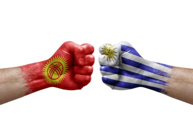 Two hands punch to each others on white background. Country flags painted fists, conflict crisis concept between kyrgyzstan and uruguay