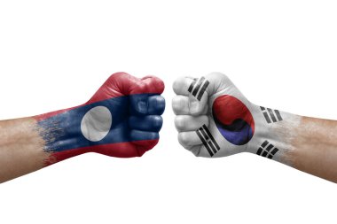 Two hands punch to each others on white background. Country flags painted fists, conflict crisis concept between laos and south korea