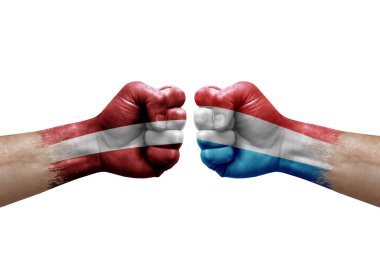 Two hands punch to each others on white background. Country flags painted fists, conflict crisis concept between latvia and luxembourg
