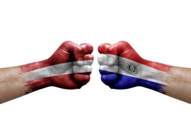 Two hands punch to each others on white background. Country flags painted fists, conflict crisis concept between latvia and paraguay