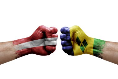 Two hands punch to each others on white background. Country flags painted fists, conflict crisis concept between latvia and saint vincent and the grenadines