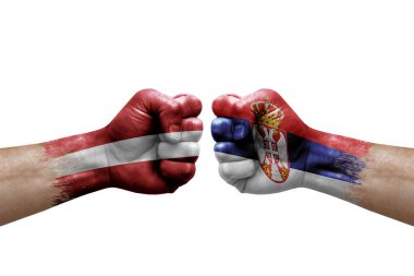 Two hands punch to each others on white background. Country flags painted fists, conflict crisis concept between latvia and serbia
