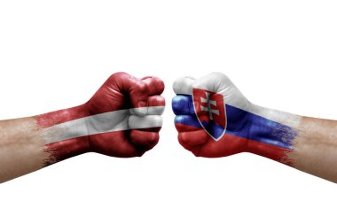 Two hands punch to each others on white background. Country flags painted fists, conflict crisis concept between latvia and slovakia