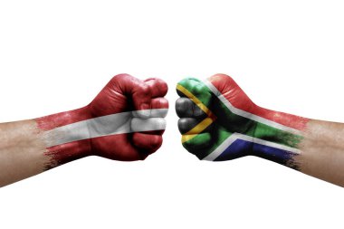 Two hands punch to each others on white background. Country flags painted fists, conflict crisis concept between latvia and south africa