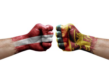 Two hands punch to each others on white background. Country flags painted fists, conflict crisis concept between latvia and sri lanka