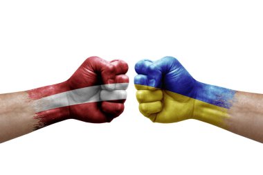 Two hands punch to each others on white background. Country flags painted fists, conflict crisis concept between latvia and ukraine